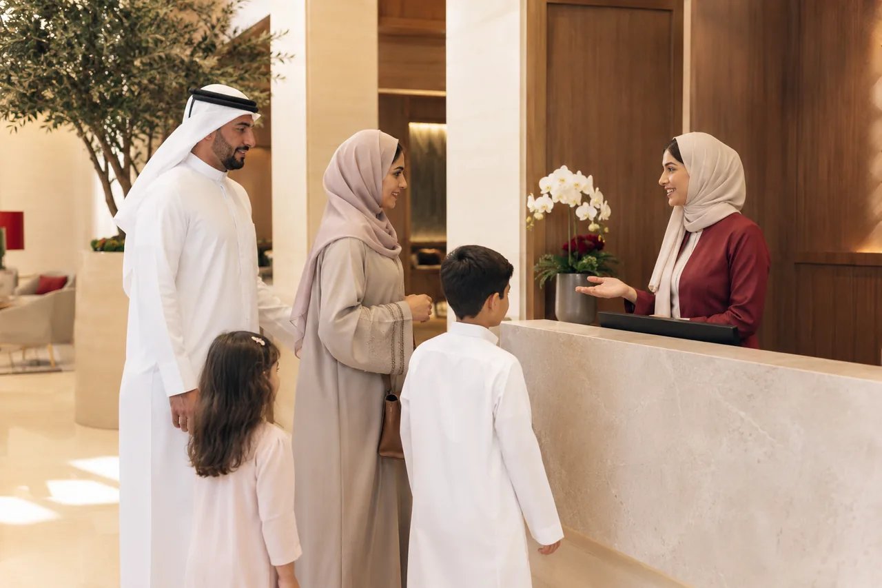 A family welcomed by a receptionist at a Bahrain medical centre
